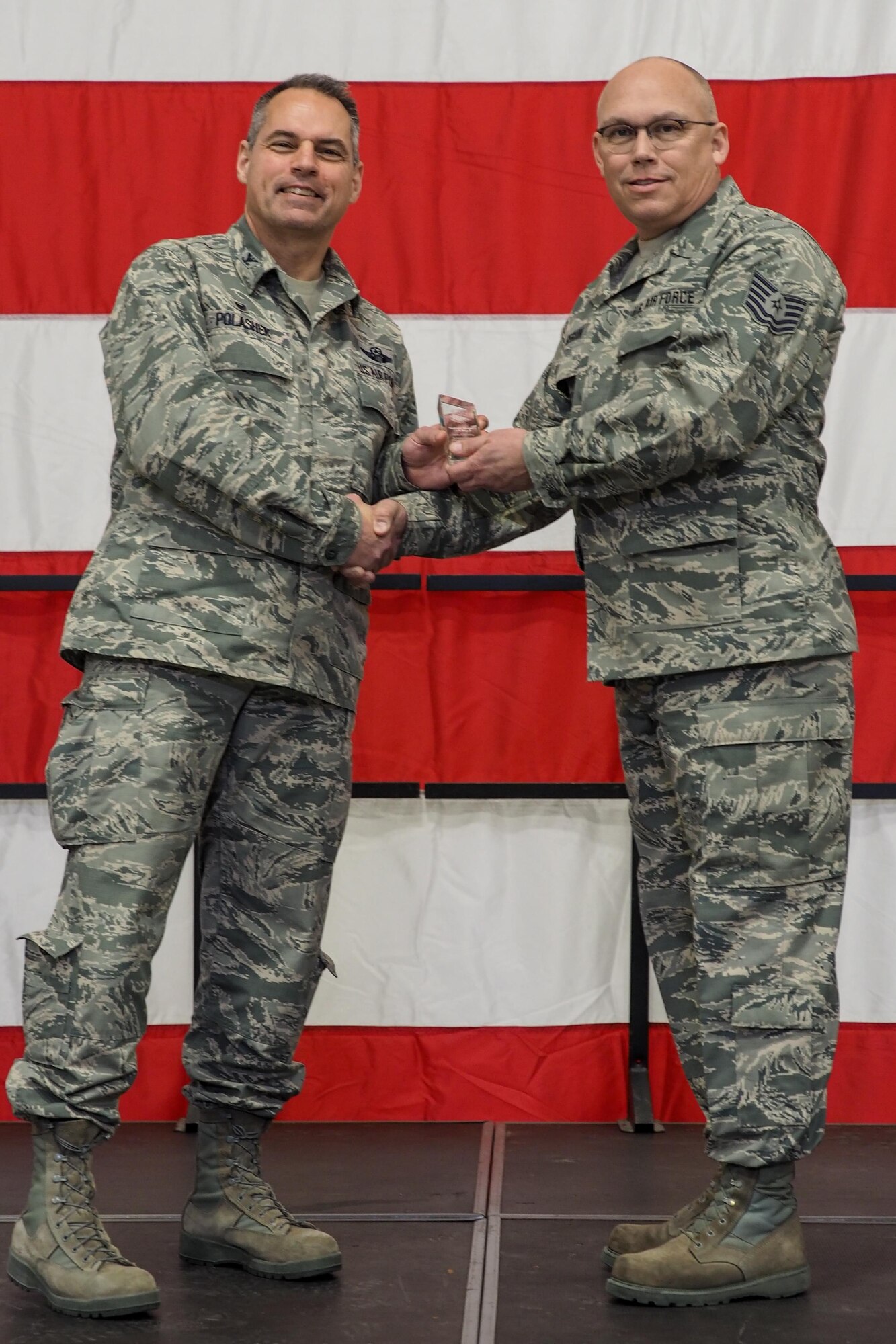 Col Tony Polashek, 934th Airlift Wing commander, presents Tech. Sgt. Chris Seguin as the Non-Commissioned Officer of the Quarter during the wing commander's call Feb. 11.