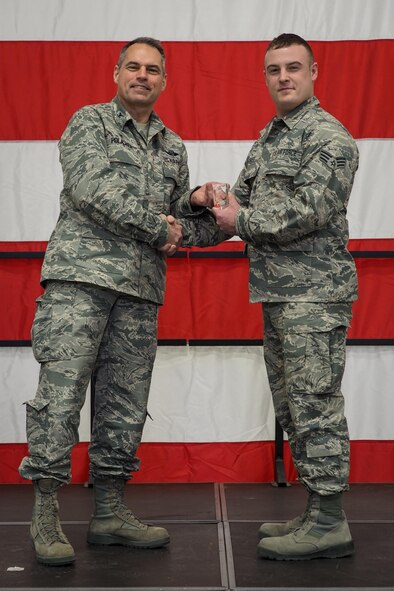 Col Tony Polashek, 934th Airlift Wing commander, presents Senior Airman Nicholas Graff as the Airman of the Quarter during the wing commander's call Feb. 11.