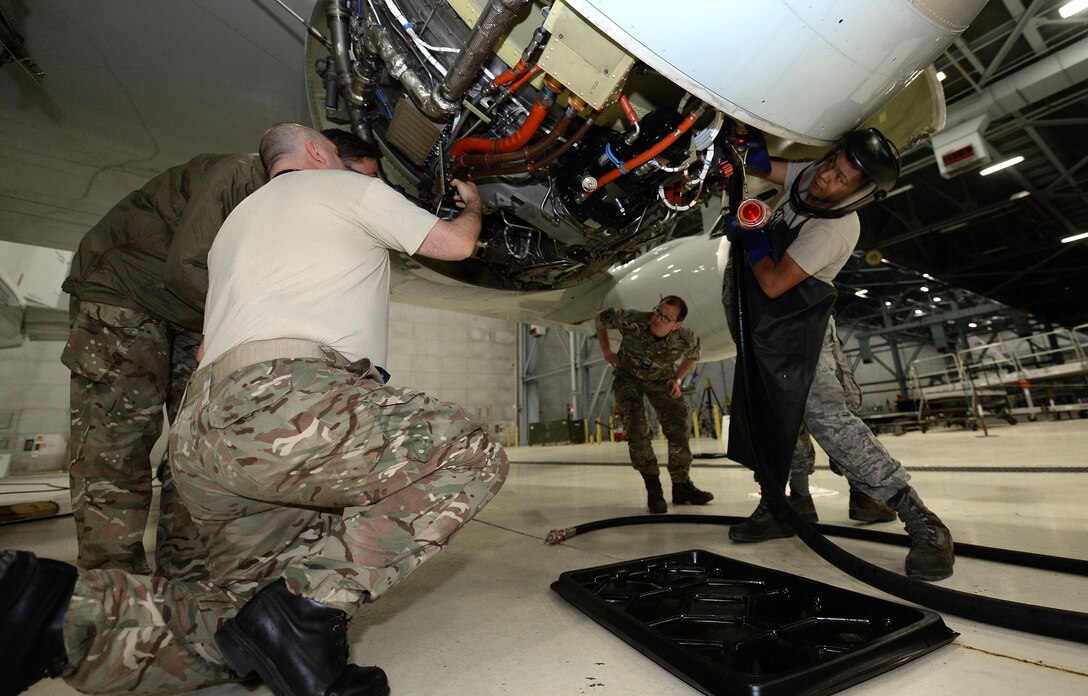 U. S. Air Force Senior Airman Roland Robicheaux Jr., a hydraulic technician from the 55th Aircraft Maintenance Squadron, hooks up an external hydraulic pressure test unit alongside Royal Air Force 51 Squadron maintenance personnel while troubleshooting landing gear problems on a RAF RC-135 Airseeker, suspended by 30 ton aircraft jacks inside a hangar at Offutt Air Force Base, Neb. Feb. 12. The aircraft diverted from Nellis Air Force Base to Offutt where it received maintenance assistance from the 55th MXG to correct a landing gear problem that occurred while participating in a joint exercise. (U.S. Air Force photo by Delanie Stafford)