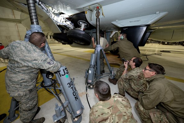 Royal Air Force 51 Squadron and 55th Maintenance Squadron maintenance personnel troubleshoot landing gear problems on a RAF RC-135 Airseeker suspended by 30 ton aircraft jacks inside a hangar at Offutt Air Force Base, Neb. Feb. 12. The aircraft diverted from Nellis Air Force Base to Offutt where it received maintenance assistance from the 55th MXG to correct a landing gear problem that occurred while participating in a joint exercise. (U.S. Air Force photo by Delanie Stafford)