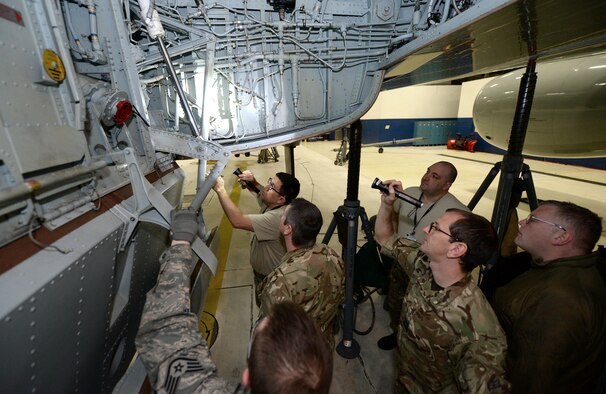 Royal Air Force 51 Squadron and 55th Maintenance Squadron maintenance personnel troubleshoot landing gear problems on a RAF RC-135 Airseeker suspended by 30 ton aircraft jacks inside a hangar at Offutt Air Force Base, Neb. Feb. 12. The aircraft diverted from Nellis Air Force Base to Offutt where it received maintenance assistance from the 55th MXG to correct a landing gear problem that occurred while participating in a joint exercise. (U.S. Air Force photo by Delanie Stafford)