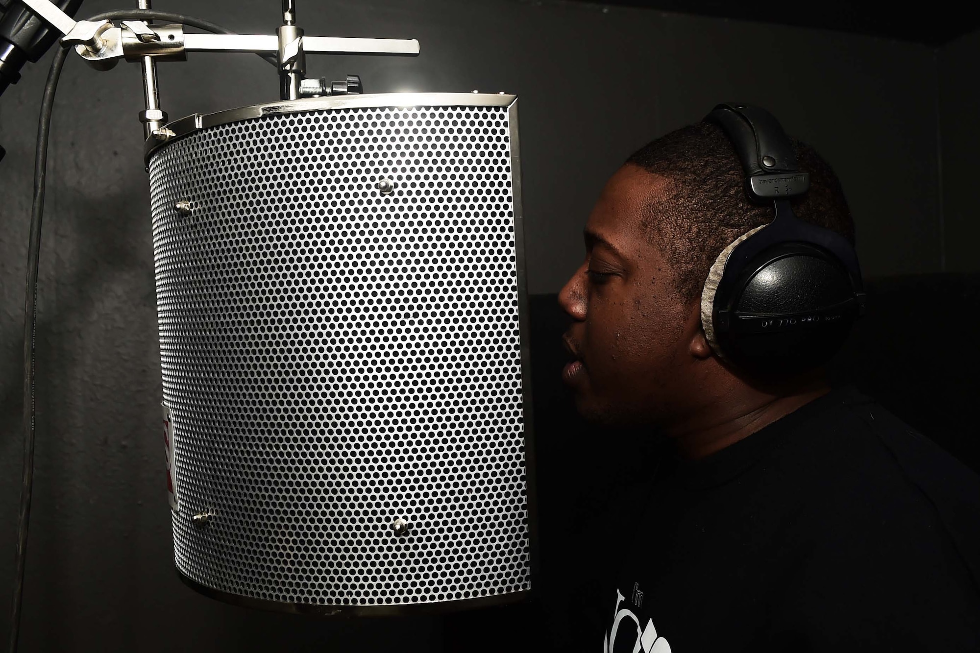 Staff Sgt. Stanley “Tyrone” Crawford, 460th Space Communications Squadron client systems technician, performs one of his own songs inside his studio Nov. 21, 2016, at his home in Aurora, Colo. Crawford began writing rap lyrics at the age of 11, but due to a life-changing event, has changed the direction of his career in order to spread the word of Christ. (U.S. Air Force photo by Airman Holden. S. Faul/Released)