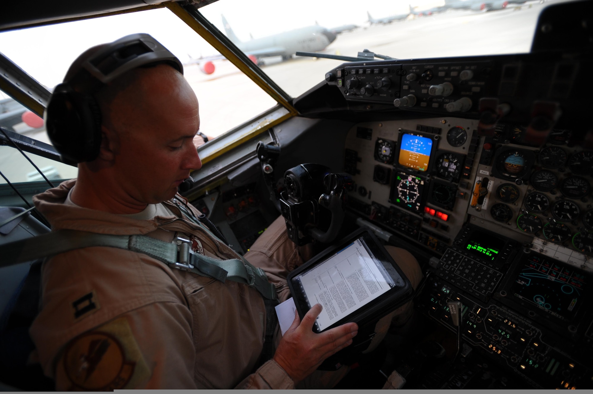 U.S. Air Force Capt. Brett Pierson, a pilot with the 340th Expeditionary Air Refueling Squadron, refers to his personal computer tablet during preflight checks aboard a KC-135 Stratotanker aircraft bound for a refueling mission in Afghanistan May 8, 2011, in support of Operation Enduring Freedom. The Hanscom Collaboration and Innovation Center at Hanscom AFB, Mass., is working with industry to provide Air Mobility Command pilots with hardened digital tablets, which can withstand digital attack and electronic interference during flight, replacing hundreds of pages of printed material with secure electronic flight bags. This acquisition method, known as a plug-test can quickly put needed tools in the hands of warfighters, before the technology is outdated. (U.S. Air Force Photo/Master Sgt. William Greer)