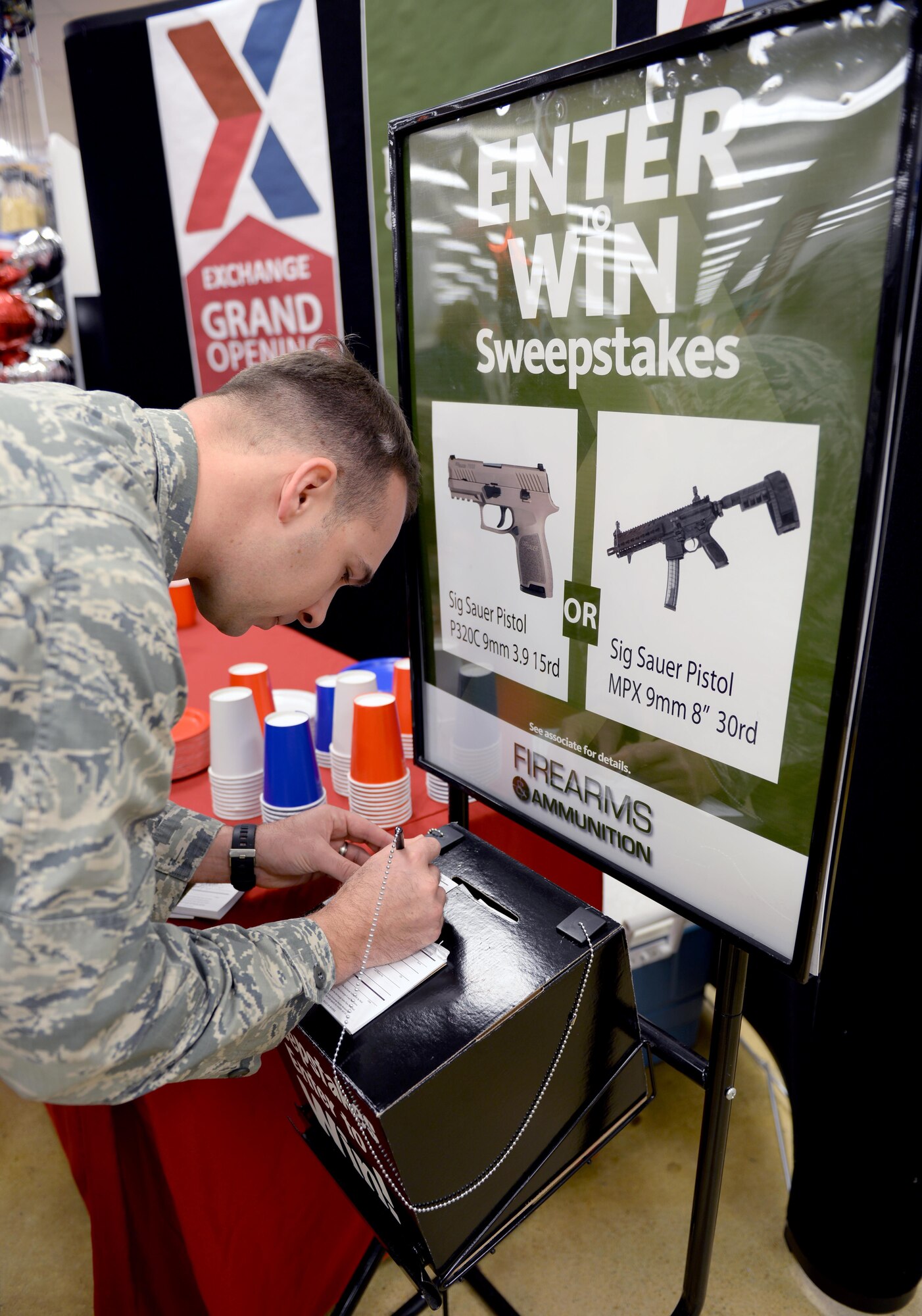 Capt. Hawkins Thomas, Air Force Reserve Officer Training Corps field trainer, completes an entry form during the grand opening of the firearms counter at the Maxwell Base Exchange, Friday, Feb. 17, 2017. The winners of the raffle will be chosen within a week. (U.S. Air Force photo/Senior Airman Tammie Ramsouer)