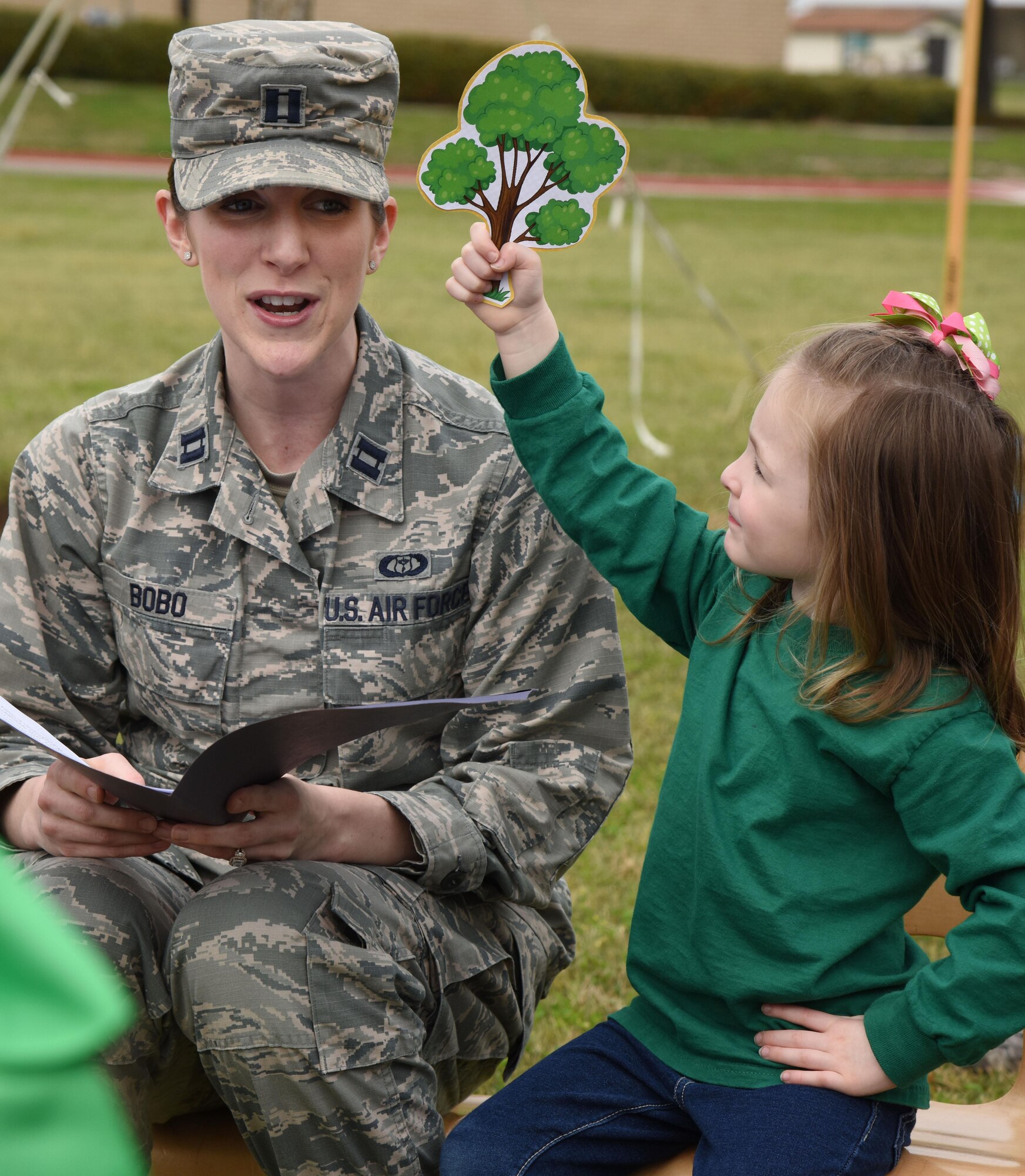 Capt. Victoria Bobo, 81st Training Wing command action group director, receives help from her daughter, Allison, with reading an Arbor Day Proclamation to children from the child development center at an Arbor Day celebration outside of the CDC Feb. 14, 2017, on Keesler Air Force Base, Miss. Keesler AFB earned the national Tree City USA honor from the Arbor Day Foundation for its 24th consecutive year. (U.S. Air Force photo by Kemberly Groue)
