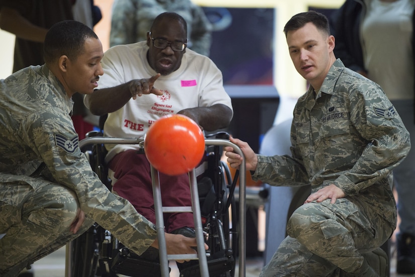 Staff Sgt. Michael Mason, left, 89th Communications Squadron government network operations center crew chief, and Senior Airman Spencer Morgan, right, 89th Communication Squadron high frequency global communication systems administrator, assist Willie Jackson, District of Columbia Special Olympics athlete, by holding the bowling ball ramp during the 2017 D.C. Special Olympics Bowling Championship at Hyattsville, Md., Feb. 16, 2017. The ramp is used for athletes that don’t have the ability to roll the ball under their own power. (U.S. Air Force photo by Senior Airman Philip Bryant)