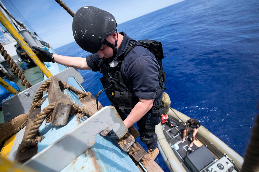 Navy Petty Officer 2nd Class James Masterson disembarks a fishing vessel during an Oceania Maritime Security Initiative boarding mission in the Pacific Ocean, Feb. 7, 2017. Masterson is a fire controlman. Navy photo by Petty Officer 3rd Class Danny Kelley