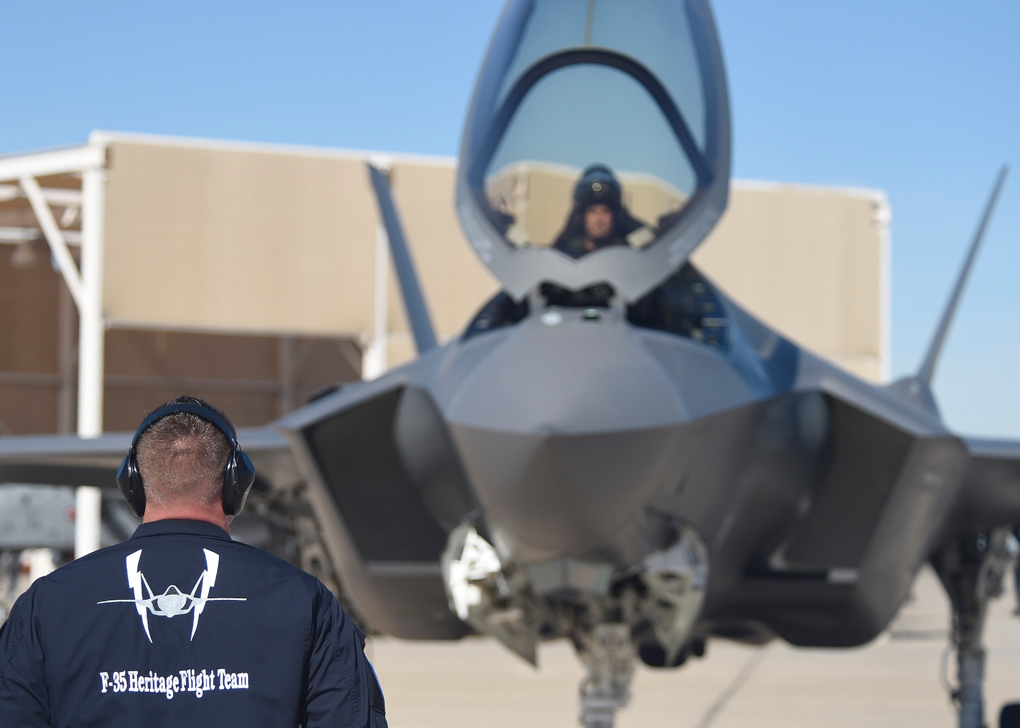 An F-35 Lightning II maintainer stands by to marshal Maj. Will Andreotta, 61st Fighter Squadron F-35 hertage flight pilot, during the Heritage Flight Training and Certification Course Feb. 10, 2017, at Davis-Monthan Air Force Base, Ariz. Heritage and demonstration teams need to be certified annually to participate in open houses and air shows worldwide. (U.S. Air Force photo by Senior Airman James Hensley)   