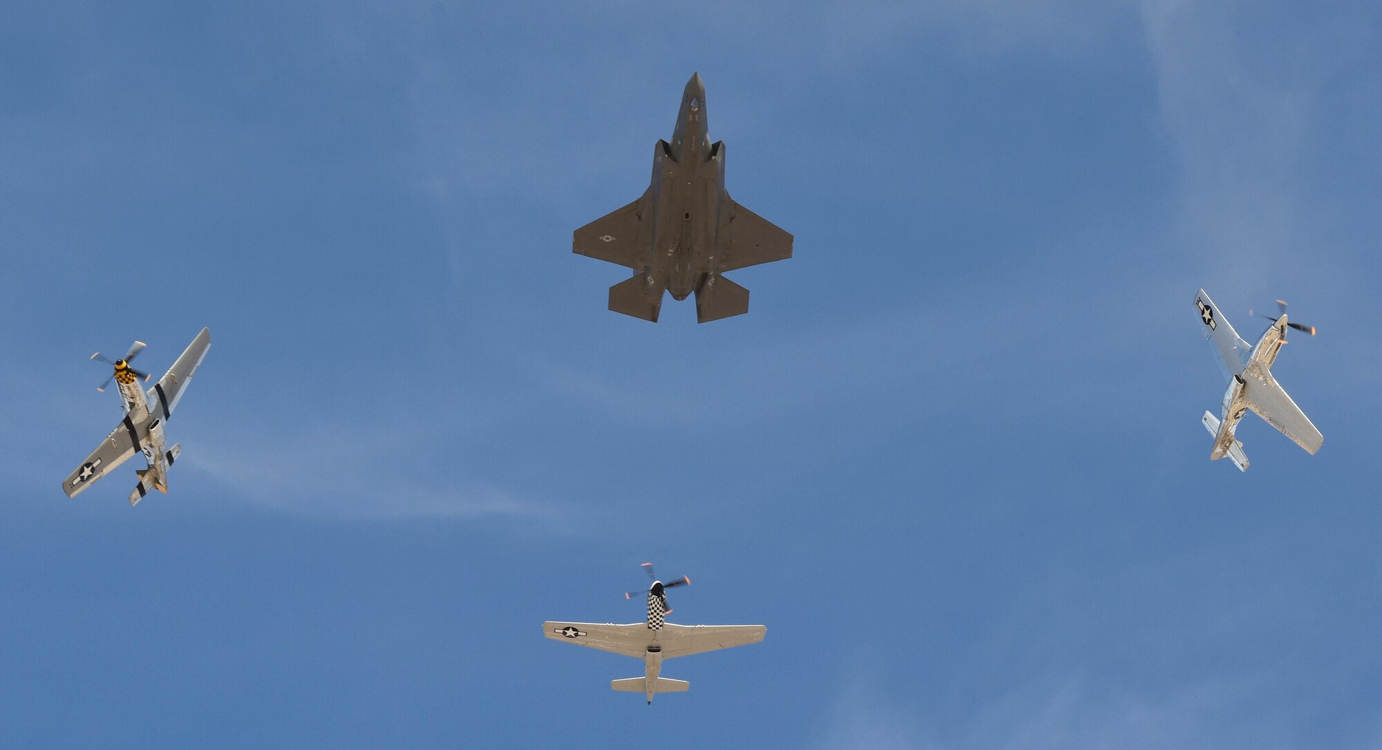 P-51 Mustangs and an F-35 Lightning II break formation during the Heritage Flight Training and Certification Course Feb. 9, 2017, at Davis-Monthan Air Force Base, Ariz. Heritage and demonstration teams need to be certified annually to participate in open houses and air shows worldwide. (U.S. Air Force photo by Senior Airman James Hensley)   