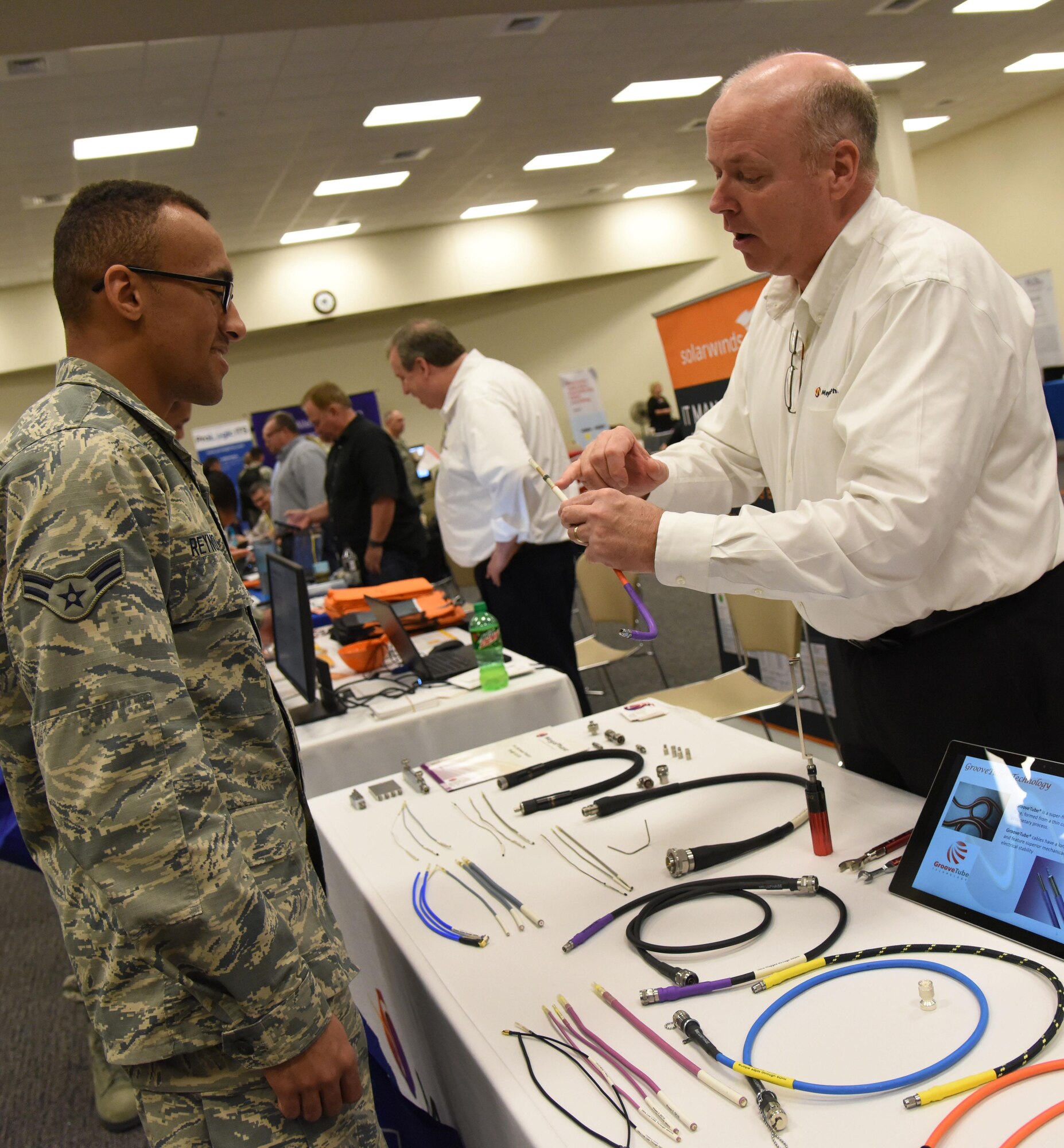 Bob Ellis, MegaPhase regional sales manager, gives an equipment brief on radio frequency cables to Airman 1st Class Noah Reynolds, 336th Training Squadron student, during the 22nd annual Technology Expo at the Roberts Consolidated Aircraft Maintenance Facility Feb. 14, 2017, on Keesler Air Force Base, Miss. The 81st Communications Squadron hosted the free event open to all Defense Department, government and contractor personnel with base access. (U.S. Air Force photo by Kemberly Groue)
