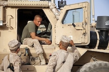 Marine veteran, Eder Campos, with Fox Company, 2nd Battalion, 2nd Marine Regiment (2/2), speaks with other Marines while preparing for a convoy mission on Camp Leatherneck, Helmand Province, Afghanistan, July 16, 2013, in support of Operation Enduring Freedom. Campos recently graduated as a candidate firefighter and emergency medical technician and is assigned to the Chicago Fire Department Engine Company 95. (U.S. Marine Corps photo by Cpl. Alejandro Pena/Released)