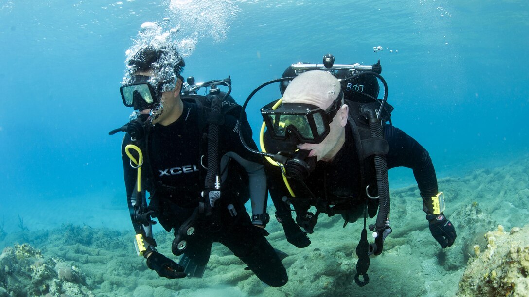 Navy Petty Officers 1st Class Jordan Delasalas, left, and Matt Bobinchak conduct diver qualification training in waters off Naval Station Guantanamo Bay, Cuba, Feb. 11, 2017. Both are assigned to Underwater Construction Team 1. Navy photo by Petty Officer 2nd Class Austin Simmons