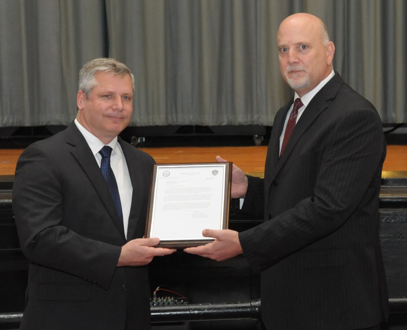 John Fedrico (R) deputy assistant Secretary of the Air Force for Reserve Affairs and Airman Readiness presents a letter of thanks to retired Air Force Lt. Col. Todd Ernst (L), during a ceremony on Feb. 13 at Joint Base San Antonio-Randolph, Texas. The letter, from Daniel Sitterly, principal deputy assistant to the Secretary of the Air Force for Manpower and Reserve Affairs, applauds Ernst’s contribution to helping ensure families of Reserve and Guard service members receive the same survivor benefits as active duty service members. (Air Force photo by Joel Martinez, Joint Base San Antonio-Randolph Public Affairs)