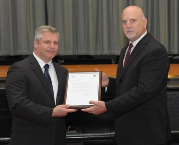 John Fedrico (R) deputy assistant Secretary of the Air Force for Reserve Affairs and Airman Readiness presents a letter of thanks to retired Air Force Lt. Col. Todd Ernst (L), during a ceremony on Feb. 13 at Joint Base San Antonio-Randolph, Texas. The letter, from Daniel Sitterly, principal deputy assistant to the Secretary of the Air Force for Manpower and Reserve Affairs, applauds Ernst’s contribution to helping ensure families of Reserve and Guard service members receive the same survivor benefits as active duty service members. (Air Force photo by Joel Martinez, Joint Base San Antonio-Randolph Public Affairs)