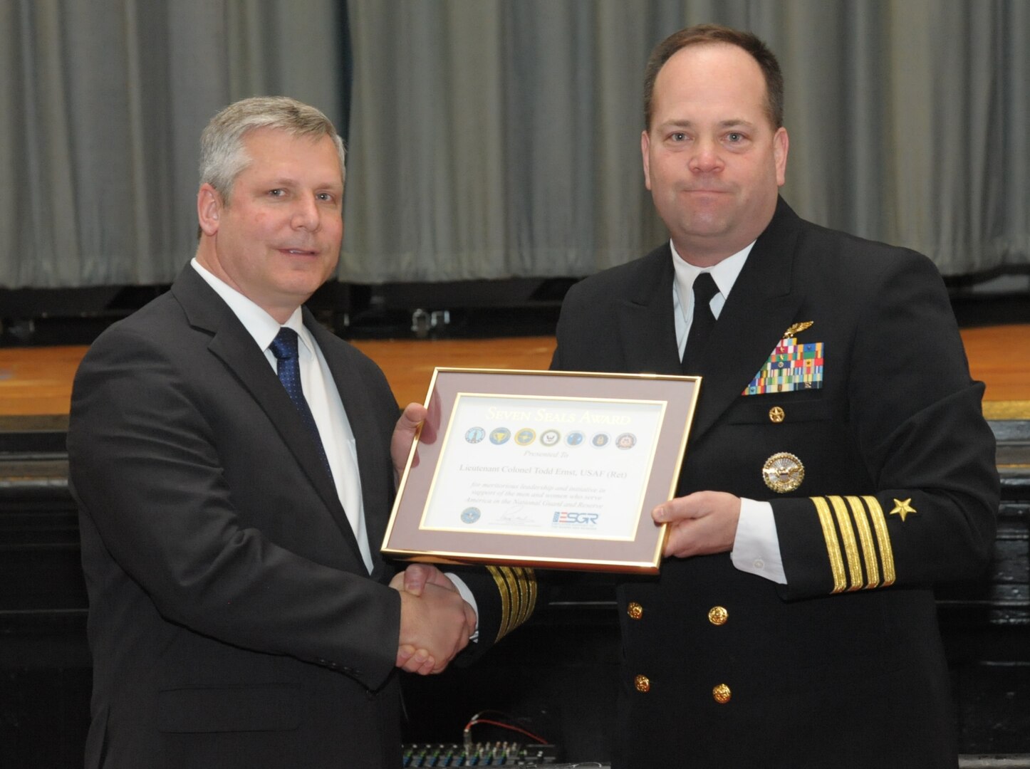 Retired Air Force Lt. Col. Todd Ernst (R) receives The Seven Seals Award from Employer Support of the Guard and Reserve (ESGR) from Navy Capt. Steve Knight (L) during a ceremony on Feb. 13 at Joint Base San Antonio-Randolph, Texas to honor him for his efforts to bring about the legislative change that now ensures families of Reserve and Guard service members receive the same survivor benefits as active duty service members. (Air Force photo by Joel Martinez, Joint Base San Antonio-Randolph Public Affairs)

