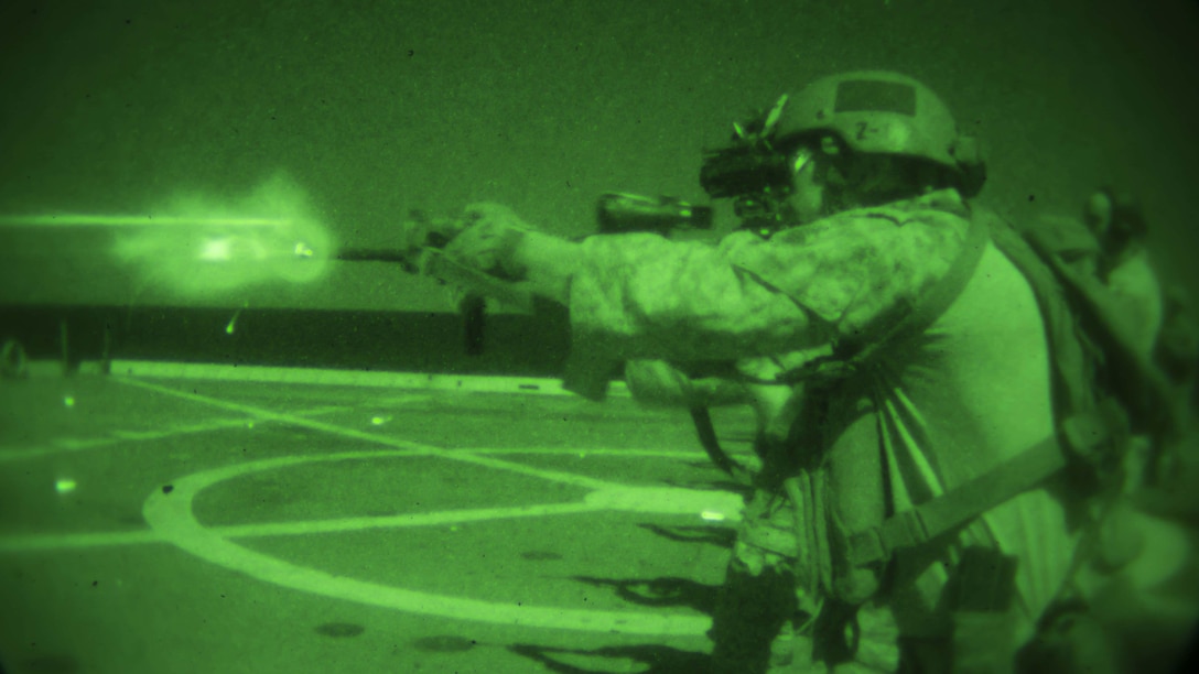 As seen through a night-vision device, Marines and sailors use infrared lasers to sight in on targets during a live-fire shoot aboard the USS Somerset in the U.S. 5th Fleet area of responsibility, Feb. 10, 2017. Marine Corps photo by Cpl. April Price