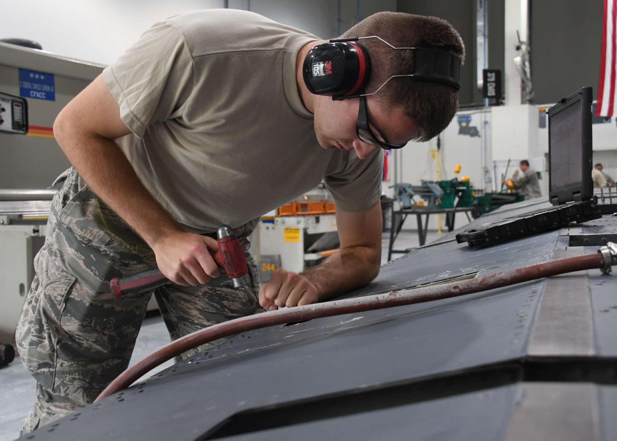 U.S. Air Force Airman 1st Class Mitchell Rogers, an aircraft structural maintenance journeyman with the 379th Expeditionary Maintenance Squadron Sheet Metal Shop, removes old rivets from an outbound flap for an aircraft at Al Udeid Air Base, Qatar, Feb. 16, 2017. A piece of metal was torn off of the flap during flight, and needed to be fixed. (U.S. Air Force photo by Senior Airman Miles Wilson)