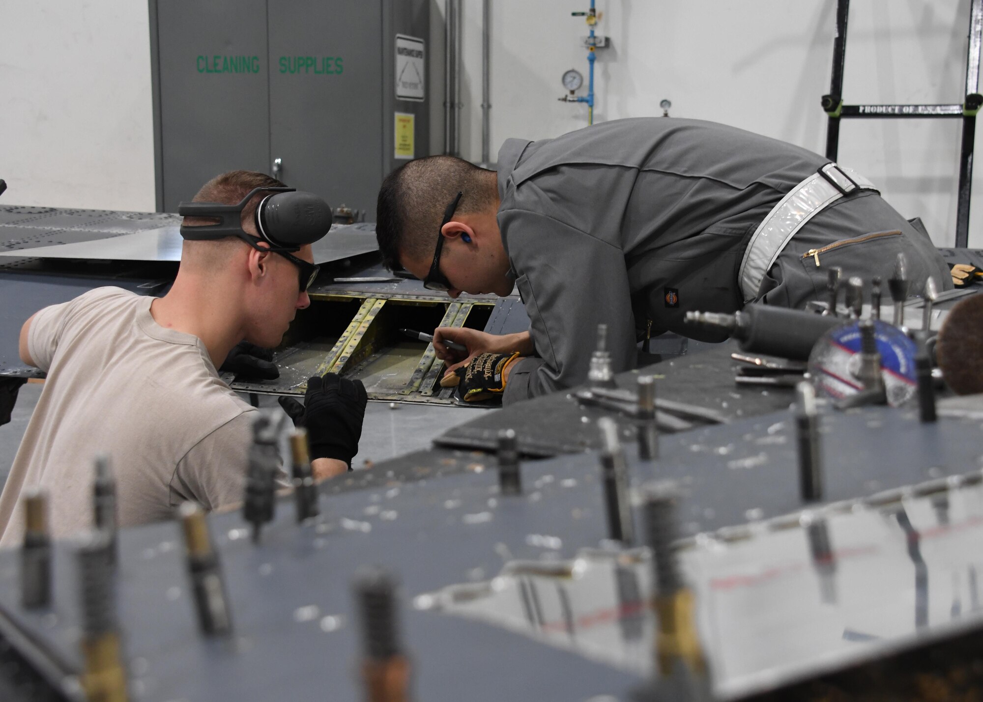 U.S. Air Force Airman 1st Class Levi Amell, left, and Senior Airman Wolfgang Kimsey, aircraft structural maintenance journeymen with the 379th Expeditionary Maintenance Squadron Sheet Metal Shop, take measurements for a replacement piece on an outbound flap for an aircraft at Al Udeid Air Base, Qatar, Feb. 16, 2017. In order to fabricate a new piece, the Airmen needed to measure the area to be replaced on the flap. (U.S. Air Force photo by Senior Airman Miles Wilson)