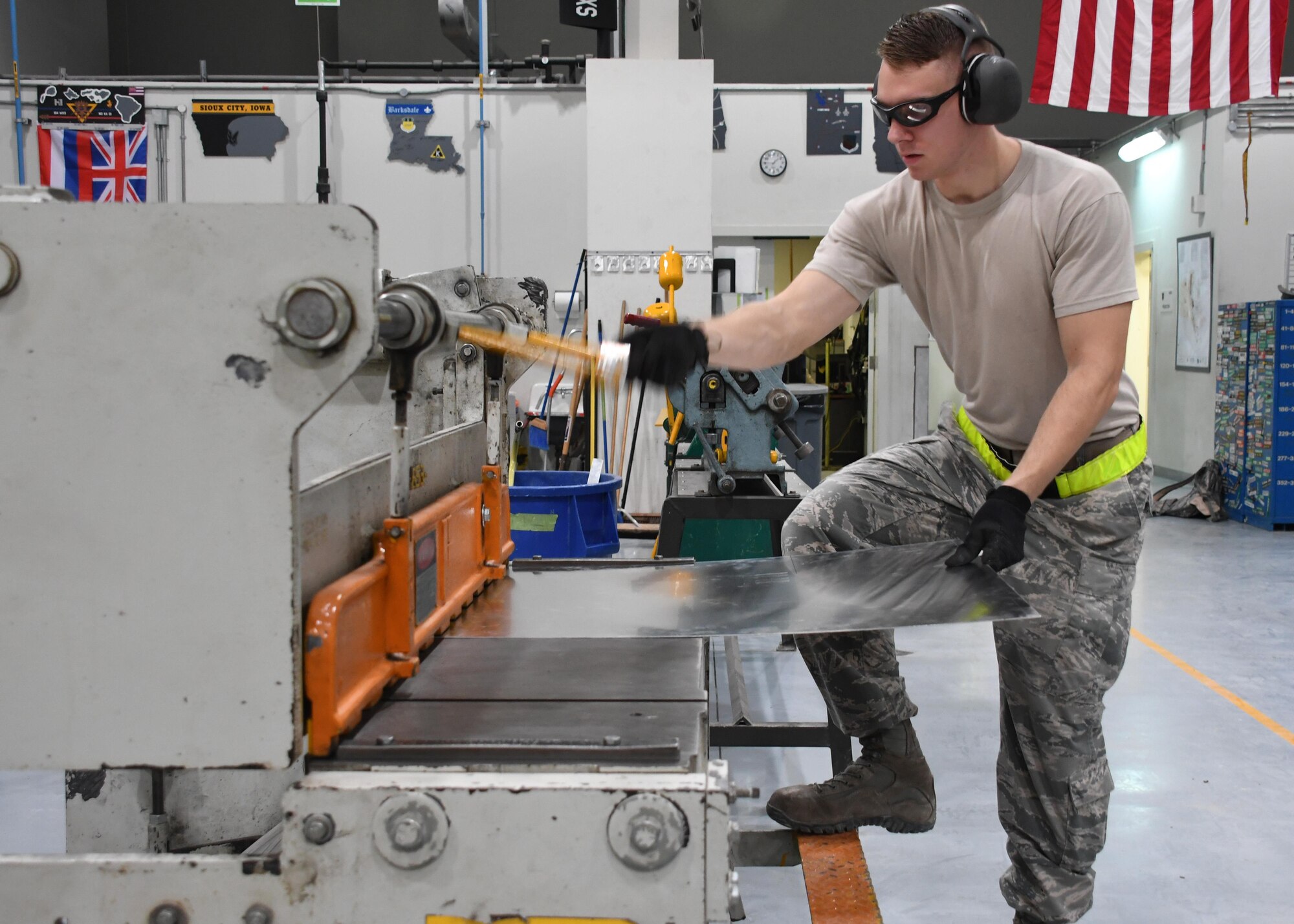 U.S. Air Force Airman 1st Class Levi Amell, an aircraft structural maintenance journeyman with the 379th Expeditionary Maintenance Squadron Sheet Metal Shop, cuts a sheet of metal using a foot shear at Al Udeid Air Base, Qatar, Feb. 16, 2017. Amell needed to cut the metal to specific measurements to fit it into place on an outbound flap for an aircraft that lost a piece of metal during flight. (U.S. Air Force photo by Senior Airman Miles Wilson)
