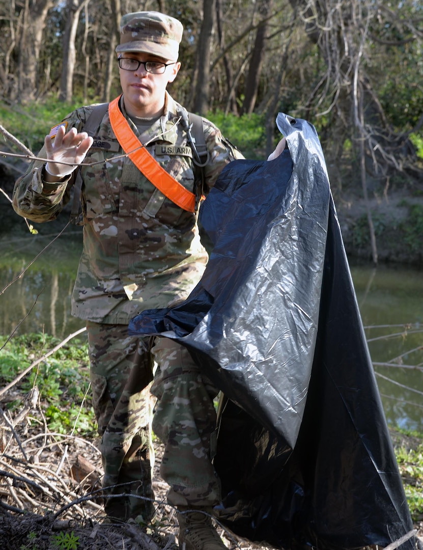Pvt. Bodine Hoge from Company E, 232nd Medical Battalion, clear trash from the banks of Salado Creek during the 2017 Basura Bash at Joint Base San Antonio-Fort Sam Houston Saturday, Feb. 18.