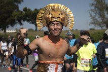 A costumed runner smiles as he's cheered on through a portion of the Okinawa Marathon Feb. 19, 2017, at Kadena Air Base, Japan. Kadena AB has supported and strengthened relations with the local community through the Okinawa Marathon for the last 25 years. (U.S. Air Force photo by Staff Sgt. Peter Reft/Released)