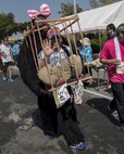 A costumed runner passes a water station during the Okinawa Marathon Feb. 19, 2017, at Kadena Air Base, Japan. The annual Okinawa Marathon is one of two full marathons in Okinawa, and is the only marathon in Japan to feature a portion of a route on a military installation. (U.S. Air Force photo by Staff Sgt. Peter Reft/Released)