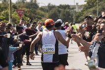 Okinawa Marathon runners high five volunteers and supporters along the route on Kadena Feb. 19, 2017, at Kadena Air Base, Japan. Approximately 500 U.S. military members and families came out to support the runners as they made their way through the base. (U.S. Air Force photo by Airman 1st Class Corey Pettis/Released)