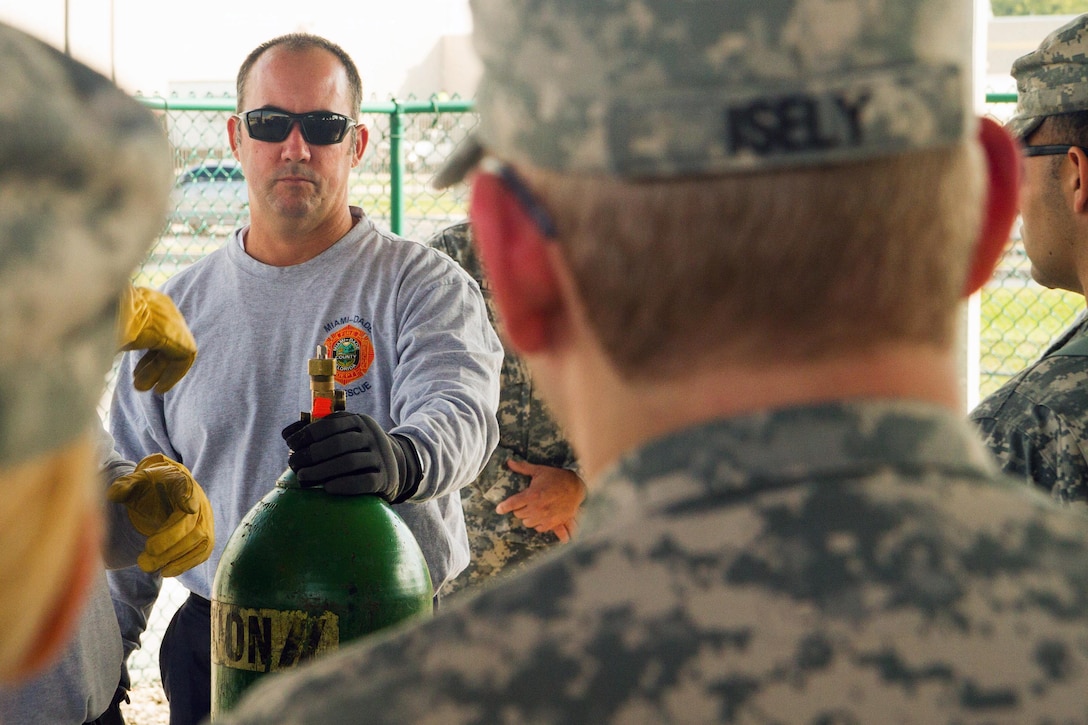 Firefighter David Guerra, a flight medic with the Miami-Dade Fire Rescue Department (MDFR), explains how to cap a valve leak on a gas cylinder to Army Reserve Soldiers assigned to the 329th Chemical, Biological, Radiological, and Nuclear (CBRN) Company (Reconnaissance and Surveillance), during training at the MDFR training facility on Feb. 17, 2017 in Doral, Fla. The 329th CBRN Company, from Orlando, Fla., the Army Reserve’s 469th Ground Ambulance Company, from Wichita, Kan., and the Florida National Guard’s Civil Support Team, spent the day training with MDFR firefighters and learned about tools Soldiers could use if called up to support hazardous material operations in Port of Miami and Dade County. (Army Reserve photo by Master Sgt. Mark Bell / Released)