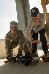 Lt. Christopher Pecori, a flight medic with the Miami-Dade Fire Rescue Department (MDFR), assists Army Reserve Spc. Lewis Colon on how to operate cutters during training at the MDFR training facility on Feb. 17, 2017 in Doral, Fla. Colon is assigned to the 329th Chemical, Biological, Radiological, and Nuclear (CBRN) Company (Reconnaissance and Surveillance), based in Orlando, Fla. He is CBRN specialist from Tampa, Fla. The 329th CBRN Company, the Army Reserve’s 469th Ground Ambulance Company, from Wichita, Kan., and the Florida National Guard’s Civil Support Team, spent the day training with MDFR firefighters and learned about tools Soldiers could use if called up to support hazardous material operations in Port of Miami and Dade County. (Army Reserve Photo by Master Sgt. Mark Bell / Released)