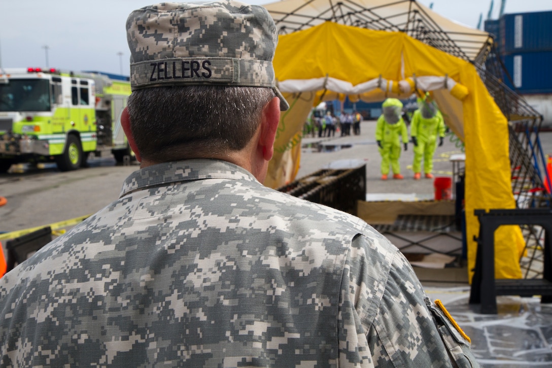 Army Reserve Warrant Officer Candidate Tod Zellers gives instructors to Soldiers approaching the decontamination station at the Port of Miami during a joint hazard material exercise with the Miami-Dade Fire Rescue Department (MDFR) on Feb. 18, 2017 in Miami, Fla. Zellers is a civilian firefighter with Seminole County Florida and is assigned to the Army Reserve’s 329th Chemical, Biological, Radiological, and Nuclear (CBRN) Company (Reconnaissance and Surveillance). The 329th CBRN Company, from Orlando, Fla., the Army Reserve’s 469th Ground Ambulance Company, from Wichita, Kan., and the Florida National Guard’s Civil Support Team, spent the day training with MDFR firefighters during a sustainment training exercise that combines civil authorities and Defense CBRN Response Force. The Miami event was the second training exercise of its kind for Northern Command. The first exercise held with a municipality was in New York City. The 329th CBRN Company is the only chemical company on the DCRF. The DCRF mission is to save lives, mitigate human suffering and facilitate recovery operations in a CBRN environment. The DCRF consists of 5,200 personnel to include Soldiers, Sailors, Airmen, Marines and civilians from active-duty and reserve component units. The DCRF is a scalable force that is part of a larger collaborative response capability between local, state, tribal and federal agencies. DCRF assets are used to support the primary agency in the event of a CBRN incident. (Army Reserve photo by Master Sgt. Mark Bell / Released)