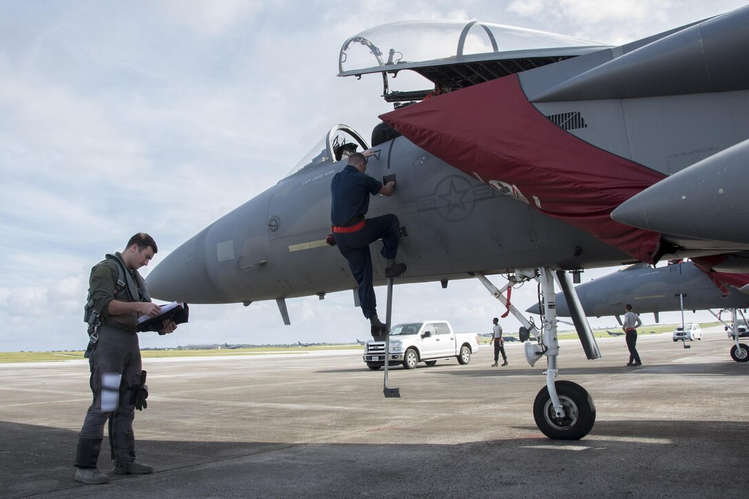 U.S. Air Force Capt. Lance Coldren, 67th Fighter Squadron F-15 Eagle pilot, goes over a pre-flight checklist as Airmen from the 67th Aircraft Maintenance Unit prep his jet Feb. 20, 2017, at Andersen Air Force Base, Guam. Aircraft and Airmen from Kadena's 67th FS, 909th Air Refueling Squadron, 961st Airborne Air Control Squadron and 18th Aeromedical Evacuation Squadron flew to Guam to participate in the 88th iteration of exercise Cope North. (U.S. Air Force photo by Senior Airman John Linzmeier/released)