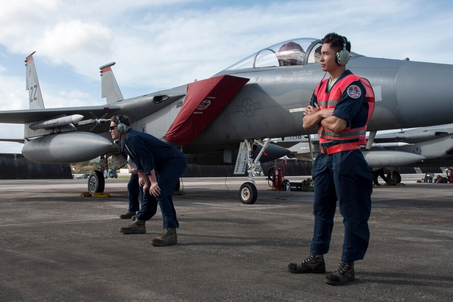 U.S. Air Force crew chiefs from the 67th Aircraft Maintenance Unit await their cue to marshal an F-15 Eagle from the 67th Fighter Squadron during annual exercise Cope North Feb. 20, 2017, at Andersen Air Force Base, Guam. Cope North provides opportunities for airmen from the U.S. Air Force, U.S. Navy, Japan Air Self-Defense Force and Royal Australian Air Force to practice combat scenarios in a controlled environment to improve tactics and cohesion among allied units. (U.S. Air Force photo by Senior Airman John Linzmeier/released)