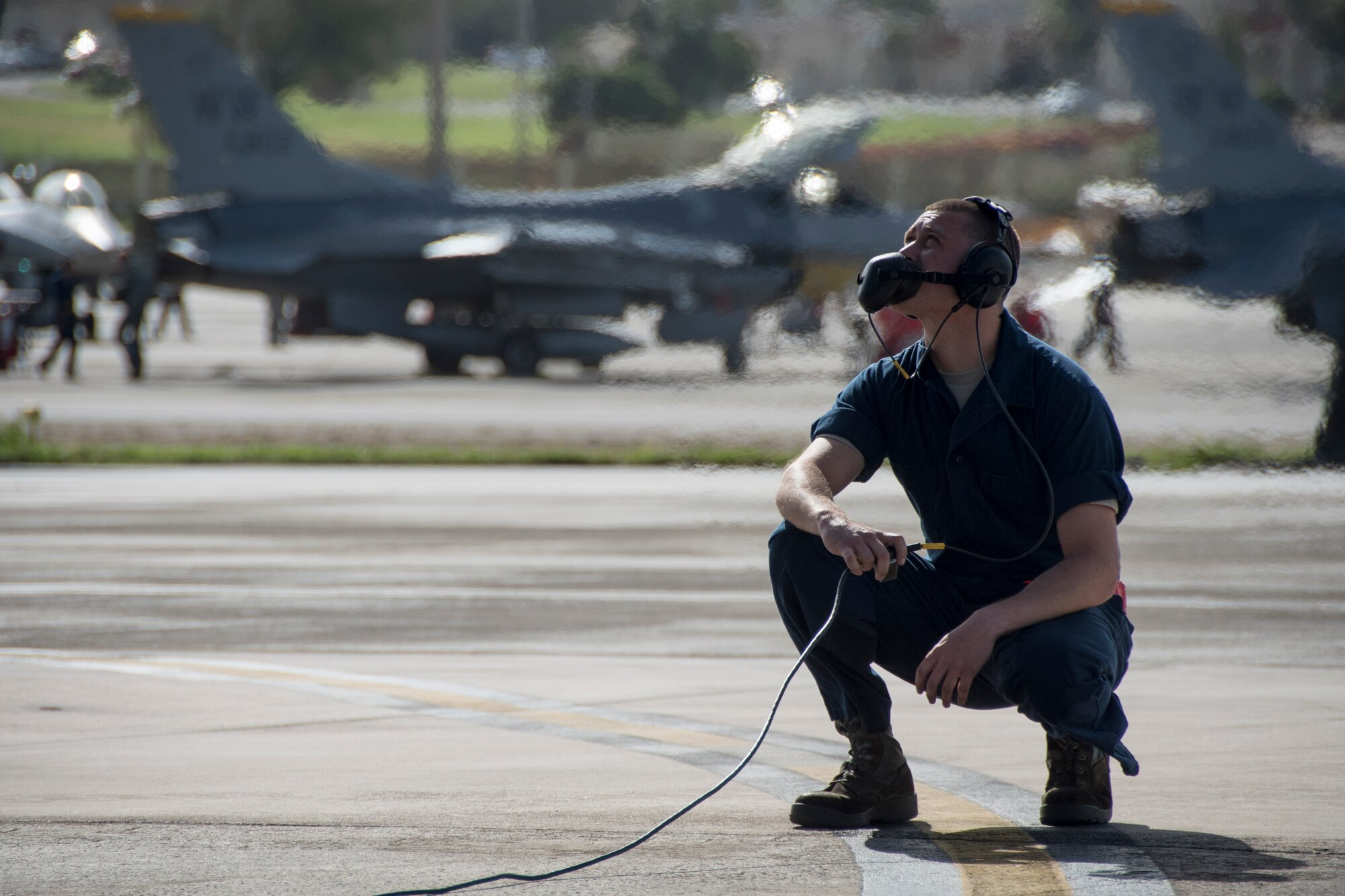 A U.S. Air Force crew chief from the 67th Aircraft Maintenance Unit waits for an F-15 Eagle pilot to start an aircraft’s engine during annual exercise Cope North Feb. 20, 2017, at Andersen Air Force Base, Guam. The maintenance performed by Airmen around-the-clock is essential for keeping aircraft running safely and effectively. Maintenance Airmen also enable Pacific Air Force units, such as the 67th FS, to protect and stabilize the Indo-Asia Pacific. (U.S. Air Force photo by Senior Airman John Linzmeier/released)