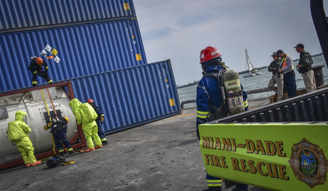U.S. Army Reserve Chemical, Biological, Radiological, and Nuclear specialists with the 329th Chemical Company based in Orlando, Fla., assist HAZMAT technicians with the Miami-Dade Fire Rescue Department with patching a hazardous leak on a container as part of a joint hazard material exercise at the Port of Miami, Feb. 18, 2017.  (U.S. Army Reserve photo by Master Sgt. Marisol Walker/Released)