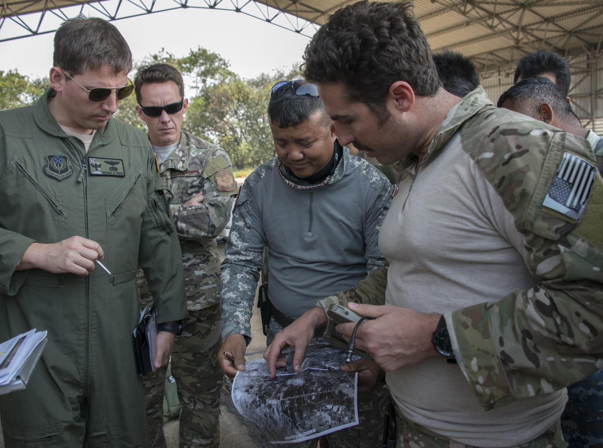 U.S. Air Force Master Sgt. David Ibson, 320th Special Tactics Squadron jump master, explains the drop zone to his counterpart from the Royal Thai Air Force Special Operations Regiment prior to jump operations from an MC-130J Commando II assigned to the 17th Special Operations Squadron, Feb. 14, 2017 at Korat Air Base, Thailand. Executing jump operations throughout Cobra Gold 2017, the members of the 320th STS and RTAF SOR demonstrate the strength of a partnership that has evolved over the last 17 years. (U.S. Air Force photo by Capt. Jessica Tait)