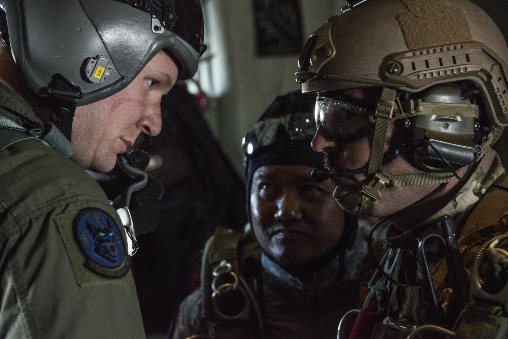 U.S. Air Force Staff Sgt. Korey King, 17th Special Operations Squadron loadmaster, Master Sgt. David Ibson, 320th Special Tactics Squadron jump master and his Royal Thai Air Force counterpart from the Special Operations Regiment discuss the timeline for jumps prior to execution, Feb. 14, 2017 at Chandy Range, Thailand. Throughout Cobra Gold 2017, the 17th SOS provided specialized aviation to members of the 320th STS and RTAF SOR in support of jump operations. (U.S. Air Force photo by Capt. Jessica Tait)