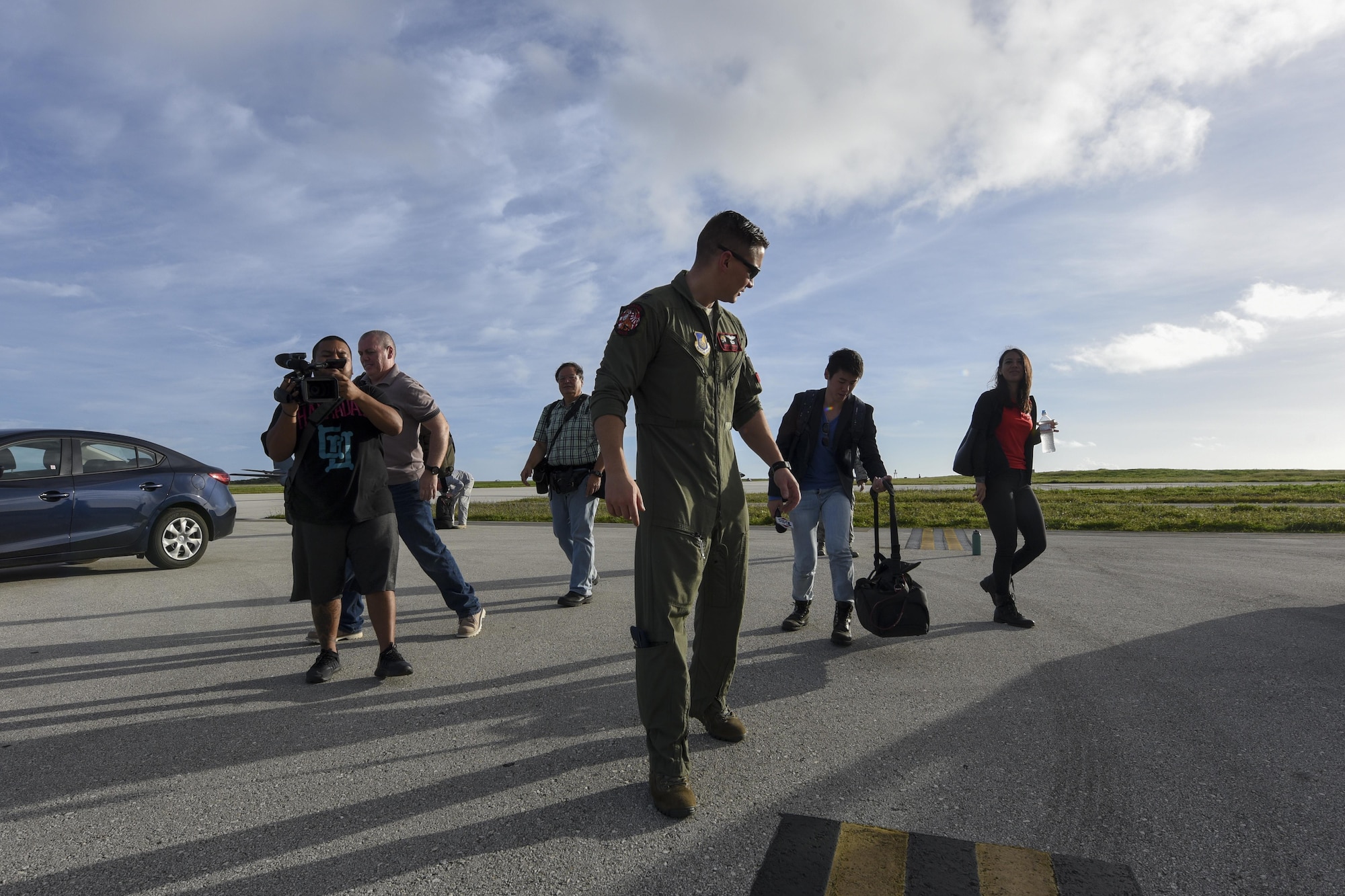 U.S. Air Force Capt. Brian Navin, 909th Air Refueling Squadron pilot, guides reporters toward an aircraft Feb. 21, 2017, at Andersen Air Force Base, Guam. Media teams visited Andersen to observe Cope North, an annual exercise designed to increase interoperability between the U.S., Japan and Australian air forces. The 909th ARS provided a flight for the visitors aboard a KC-135 Stratotanker for an observation of air-refueling operations. (U.S. Air Force photo by Senior Airman John Linzmeier/released)
