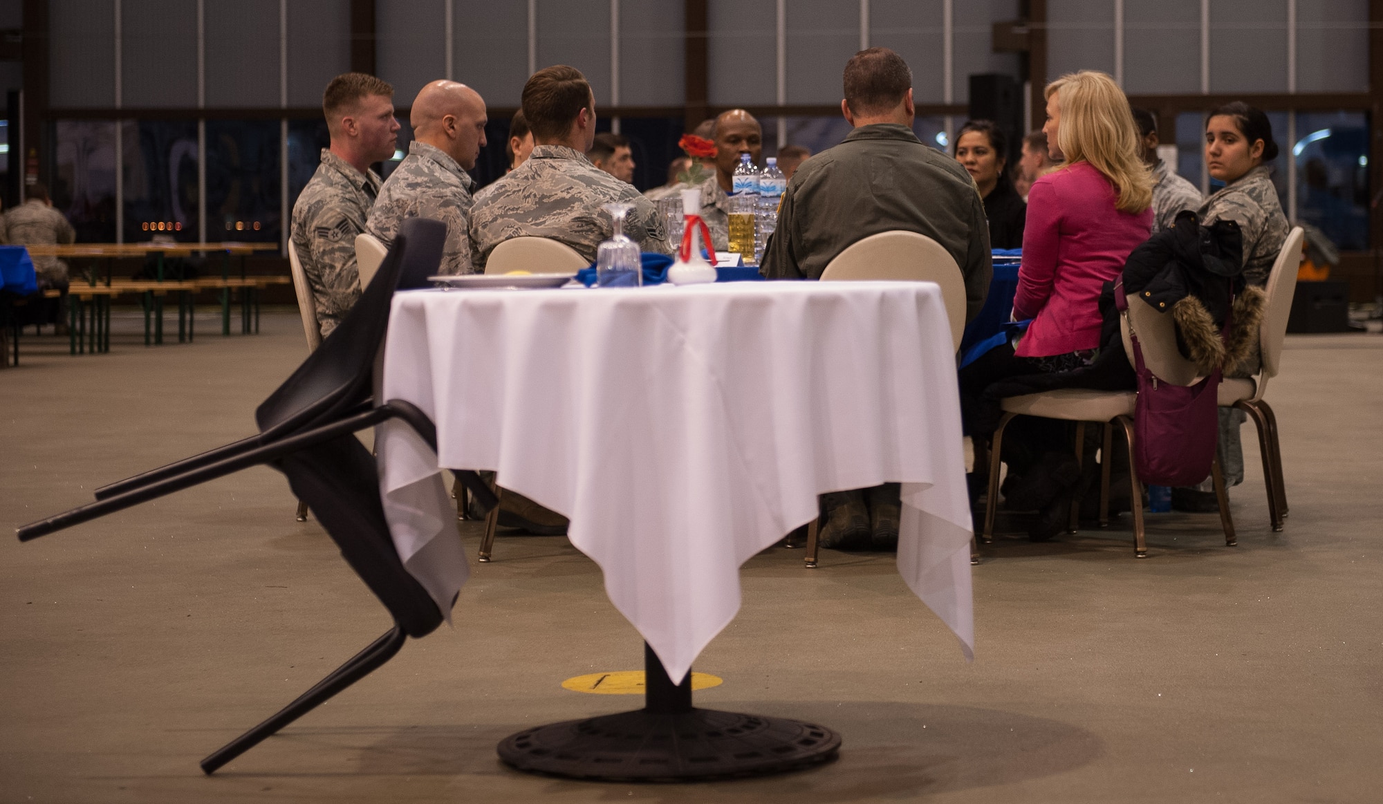 A POW/MIA table sits in front of a crowd during the 2016 Maintenance and Logistics Airmen Annual Award Ceremony on Ramstein Air Base, Germany, Feb. 17, 2017. Also known as the missing man table, the setup is used in military dining facilities of the U.S. armed forces and during special occasions to commemorate the fallen, missing, or imprisoned service members. It originated out of U.S. concern of the Vietnam War’s large POW/MIA numbers. (U.S. Air Force photo by Senior Airman Lane T. Plummer)