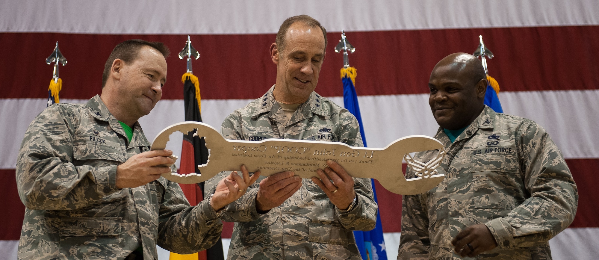 Lt. Gen. John B. Cooper, headquarters U.S. Air Force deputy chief of staff for logistics, engineering and force protection, receives a gift from Col. Paul Filcek, 86th Maintenance Group commander, and Col. Uduak Udoaka, 86th Logistics Readiness Squadron commander, at the 2016 Maintenance and Logistics Airmen Annual Award Ceremony on Ramstein Air Base, Germany, Feb. 17, 2017. Cooper joined Airmen who received annual awards on stage to reward them for their hard work throughout 2016. (U.S. Air Force photo by Senior Airman Lane T. Plummer)