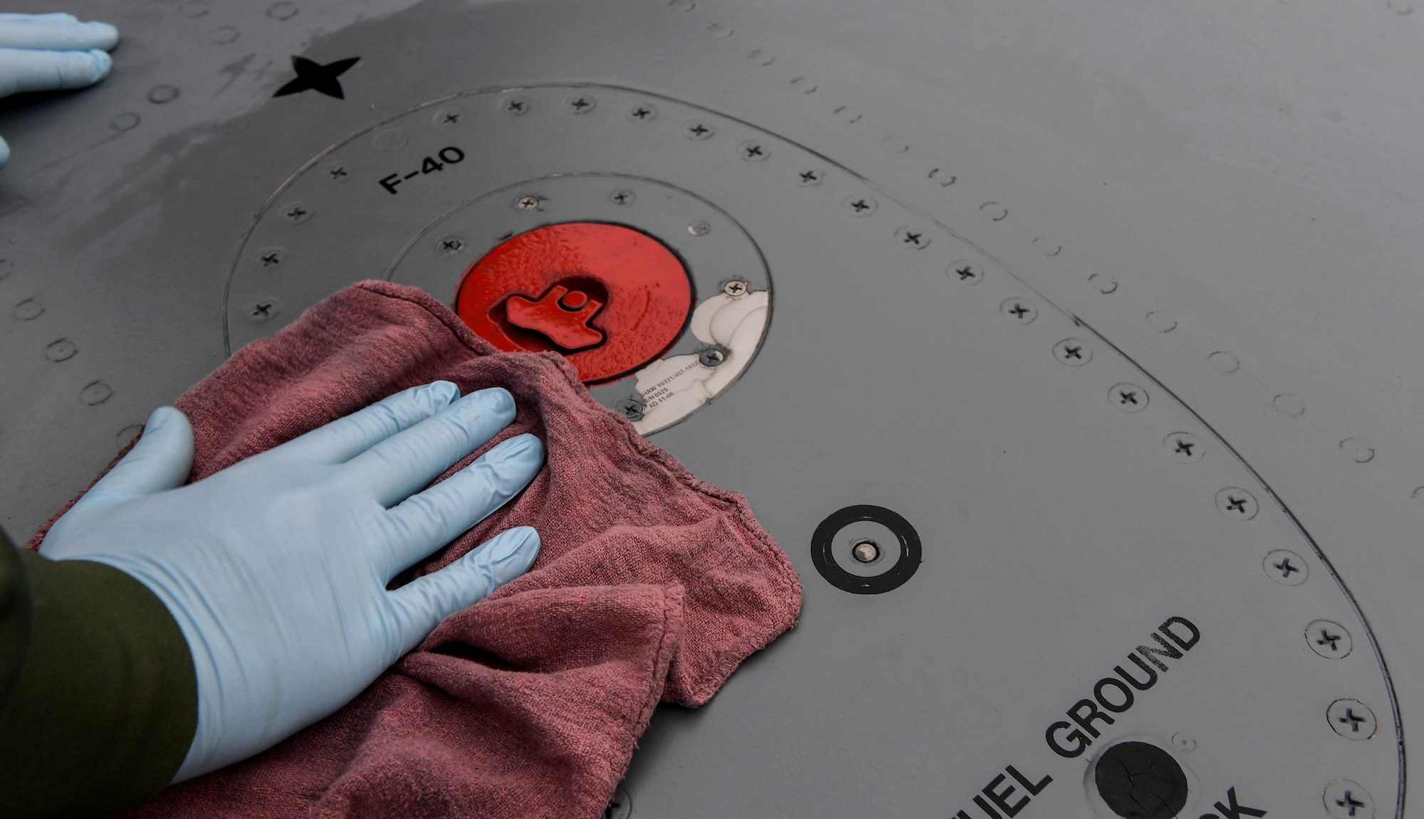 Staff Sgt. Kyle Brooks, 721st Aircraft Maintenance Squadron aircraft fuel systems technician, wipes down the area of a number four main fuel tank leak on the wing of a C-17 Globemaster III in Cologne, Germany, Feb. 10, 2017. The leak was dripping fuel down the wing and behind the fourth engine exhaust. (U.S. Air Force photo by Senior Airman Tryphena Mayhugh)