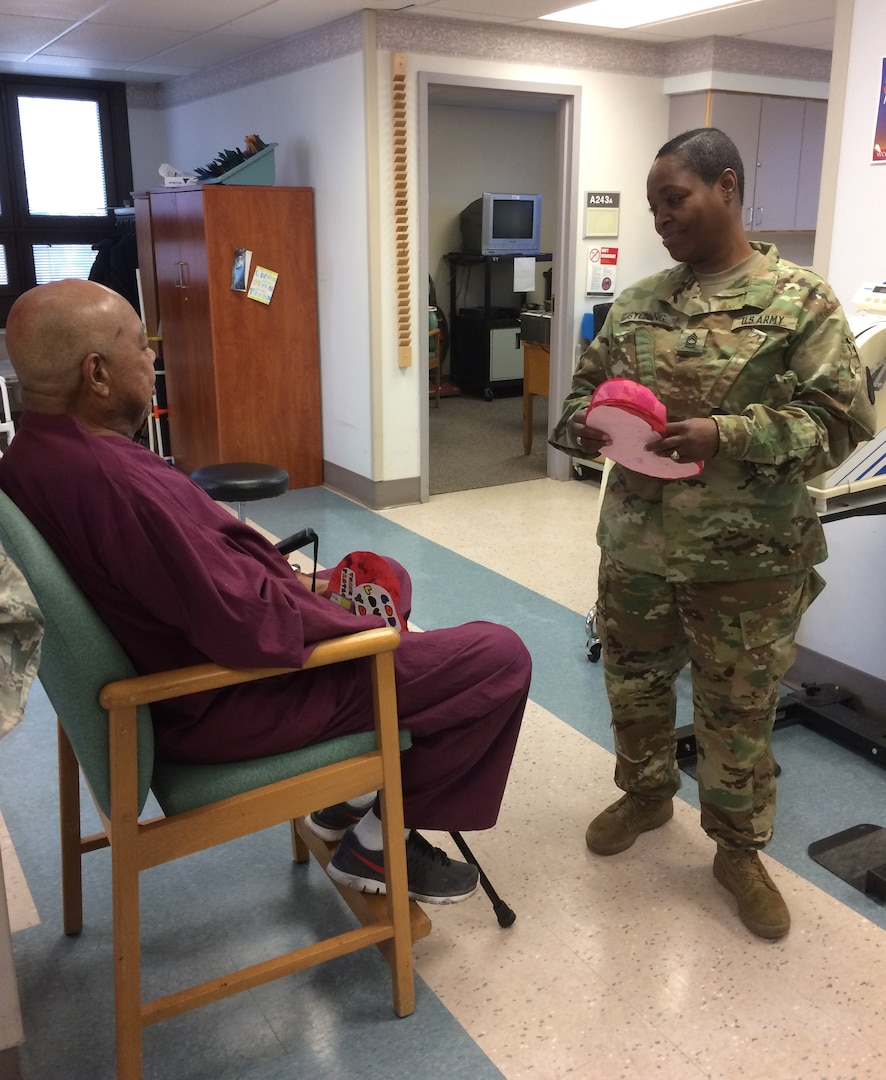 DLA Troop Support Commander Army Brig. Gen. Charles Hamilton talks with a veteran undergoing physical therapy at the Michael J. Crescenz Veteran Medical Center in Philadelphia Feb. 17. A group of soldiers, sailors and airmen assigned to DLA Troop Support met with veterans in the care of the Crescenz Medical Center team as part of the 40th annual National Salute to Veterans Patient Week.