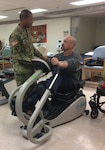 DLA Troop Support Commander Army Brig. Gen. Charles Hamilton talks with a veteran undergoing physical therapy at the Michael J. Crescenz Veteran Medical Center in Philadelphia Feb. 17. A group of soldiers, sailors and airmen assigned to DLA Troop Support met with veterans in the care of the Crescenz Medical Center team as part of the 40th annual National Salute to Veterans Patient Week.