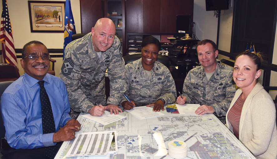 72nd Air Base Wing Commander Col. Stephanie Wilson, 72nd ABW Command Chief Master Sgt. David Tuck and the 72nd Mission Support Group Commander Col. Michael Green, sign pledge cards kicking off Military Saves week. Present are Rickie Smith, director of the Airman & Family Readiness Center, and Gia Easley, Military Saves POC. (Courtesy photo)
