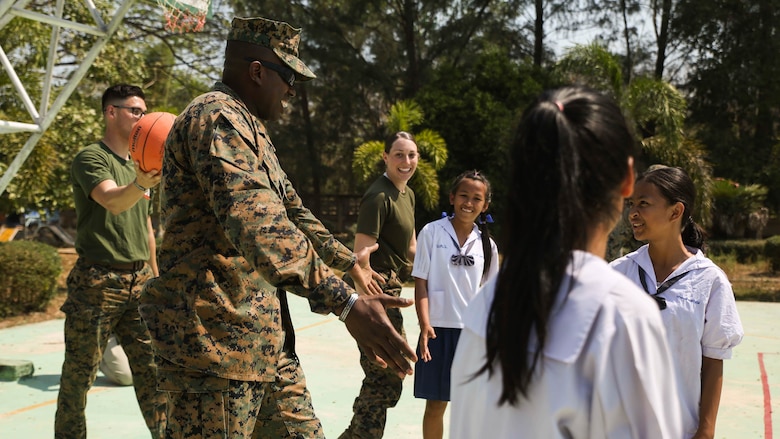 U.S. Marine Corps 1st Sgt. Trevor A. Highsmith, company first sergeant for Transportation Services Company, Combat Logistics Battalion 4, III Marine Expeditionary Force, congratulates his teammates during a basketball game Feb. 15, 2017 at Ban Khok Wat School, Chanthaburi, Thailand. Thai, U.S. and partner nation service members participated in community relation projects at various locations throughout the Royal Kingdom of Thailand during Exercise Cobra Gold 2017. Similar to last year, Cobra Gold 17 emphasizes coordination on civic action, such as humanitarian assistance and disaster relief, seeking to expand regional cooperation and collaboration in these vital areas. (U.S. Marine Corps photo by Sgt. Tiffany Edwards/Released)