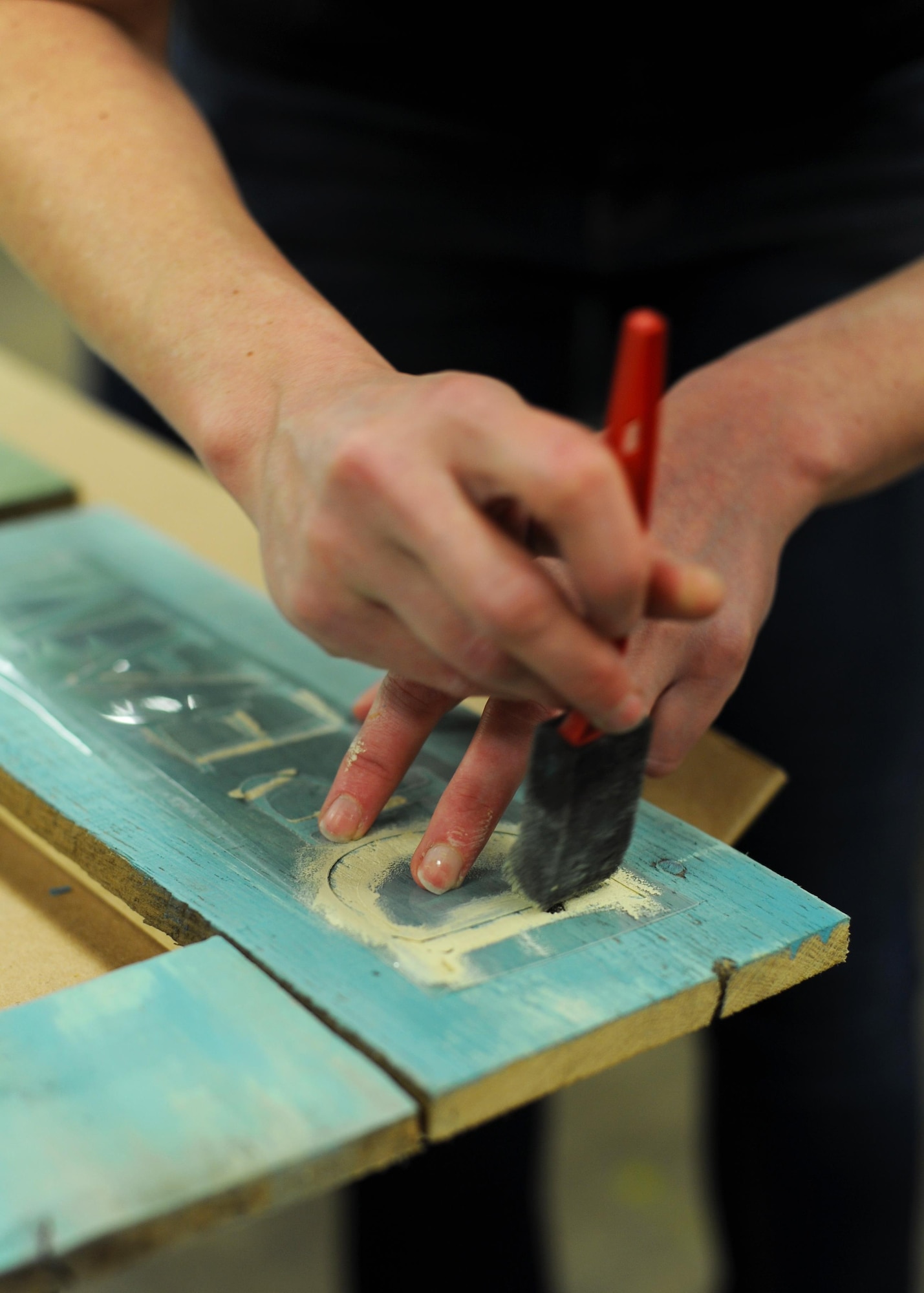 A customer uses a stencil to put words on a picture frame during a class Feb. 15, 2017, at the 19th Force Support Squadron Skills and Development Center Wood Frame Shop on Little Rock Air Force Base, Ark. Participants were given two hours to make their own unique decoration with the help of staff. (U.S. Air Force photo by Airman 1st Class Grace Nichols)