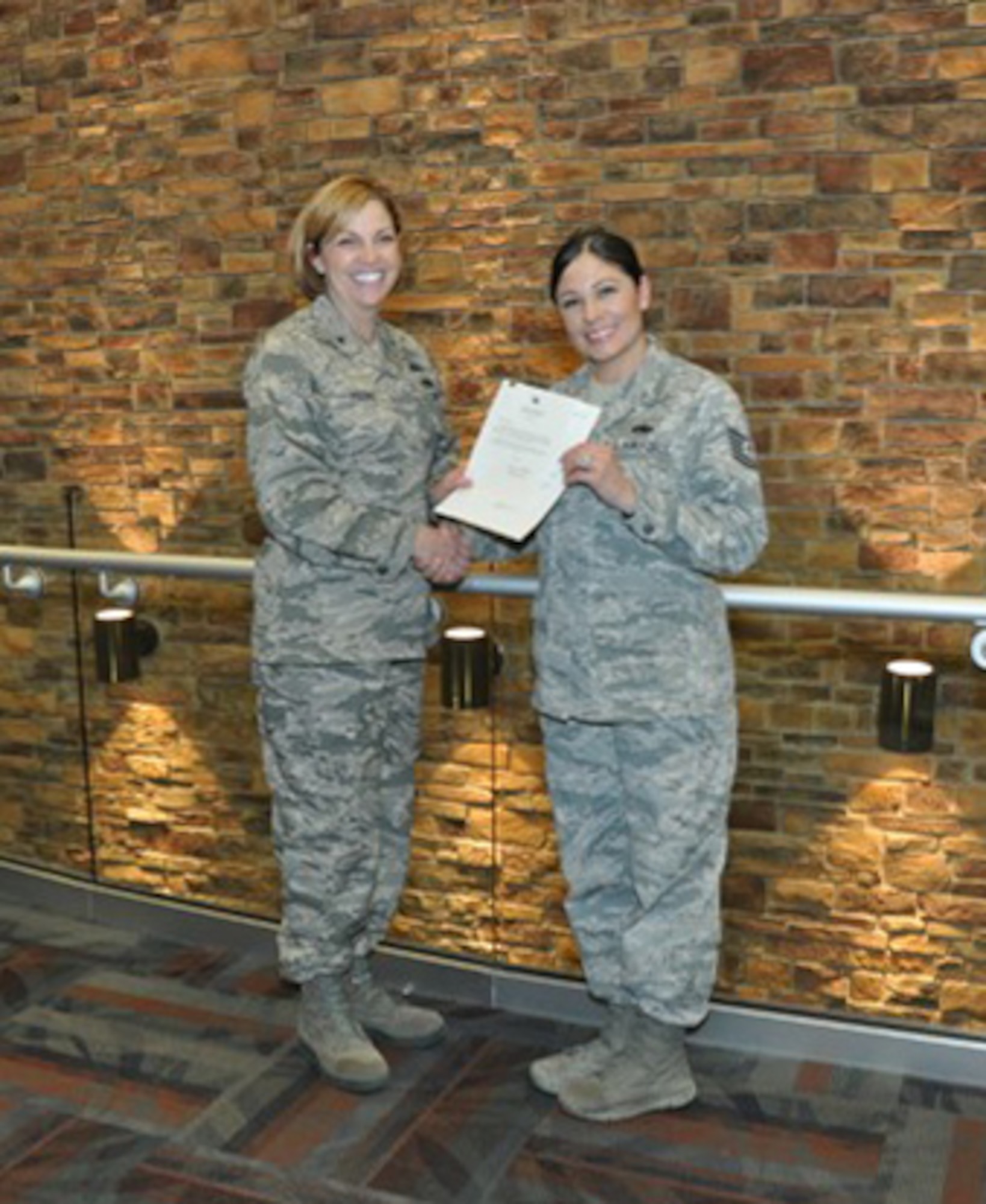 Brig. Gen. Ellen Moore (left), Air Reserve Personnel Center commander, presents Tech. Sgt. Amee Espinoza, Personnel Customer Service Manager for the ARPC Total Force Service Center, with a letter of congratulations from Lt. Gen. Maryanne Miller, commander of Air Force Reserve Command, for her selection as the AFRC nomination for the 2016 GEICO Military Service Award. Espinoza completed more than 600 hours of direct and indirect counseling services with individuals and groups focused on DUI and DWIs, addiction, domestic violence, conflict resolution, and anger management. (U.S. Air Force photo by Master Sgt. Beth Anschutz)