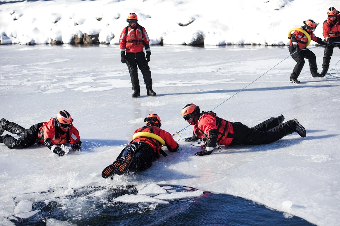 Members of the U.S. Coast Guard and Air Force Maj. Gen. Steven Cray, adjutant general, Vermont National Guard, pull a simulated cold water victim from Lake Champlain during ice water rescue training at Coast Guard Station Burlington, Vt., Feb. 17, 2017. Air National Guard photo by Tech. Sgt. Sarah Mattison