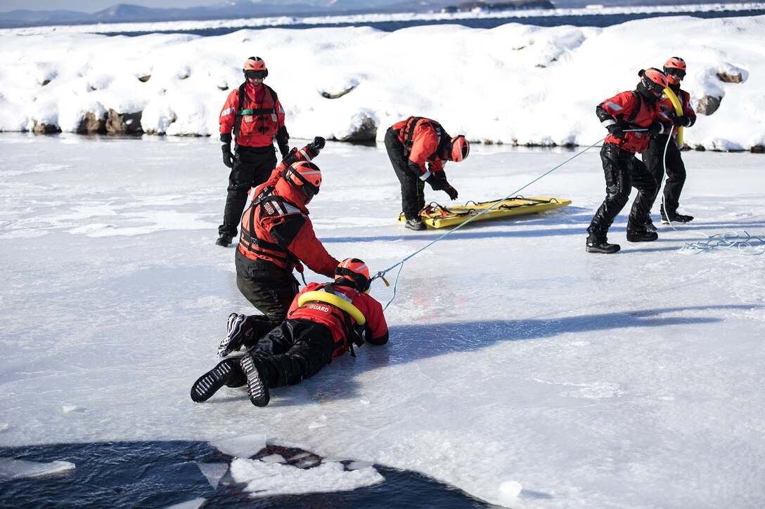 U.S. Coast Guardsmen rescue a simulated cold water victim from Lake Champlain during ice water rescue training at Coast Guard Station Burlington, Vt., Feb. 17, 2017. Air National Guard photo by Tech. Sgt. Sarah Mattison 