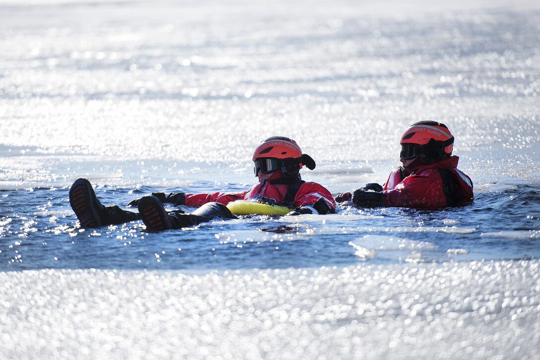 Coast Guard Rear Adm. Steven Poulin, left, commander, First Coast Guard District, role-plays as a simulated cold water victim and is rescued from Lake Champlain during ice water rescue training at Coast Guard Station Burlington, Vt., Feb. 17, 2017. Air National Guard photo by Tech. Sgt. Sarah Mattison