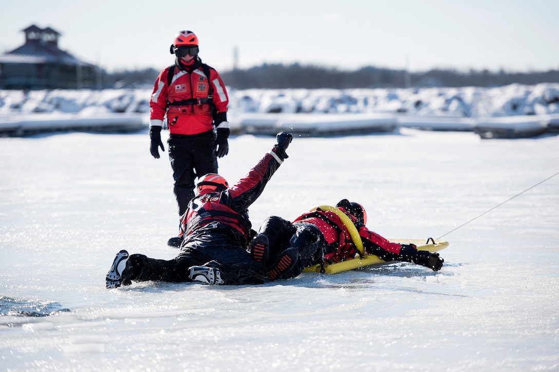 A Coast Guardsman uses a sled to rescue a simulated cold water victim from Lake Champlain during ice water rescue training at Coast Guard Station Burlington, Vt., Feb. 17, 2017. Air National Guard photo by Tech. Sgt. Sarah Mattison